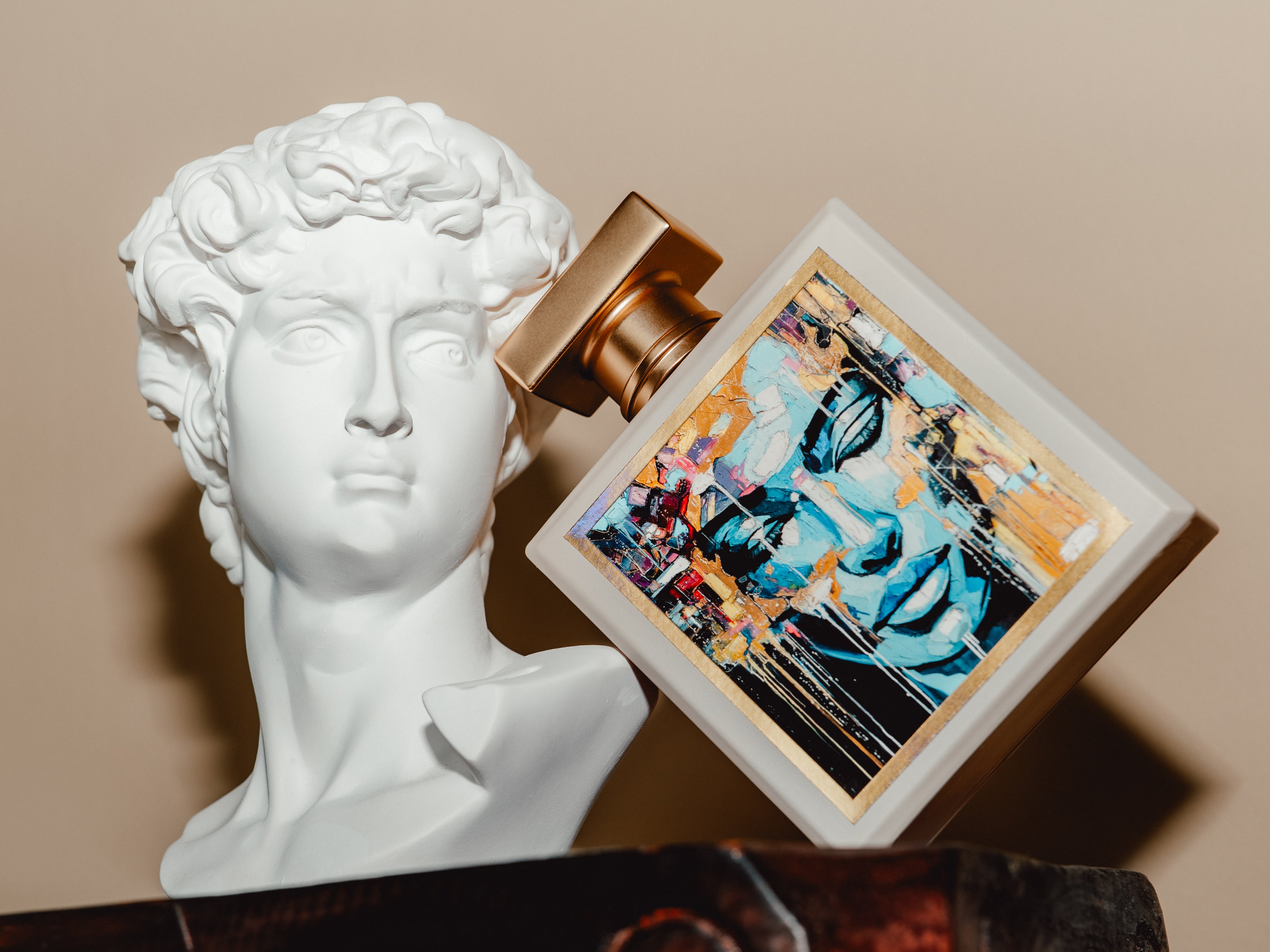 Frontview of our luxury parfum together with a statue of David, showcasing our creative aspiration.